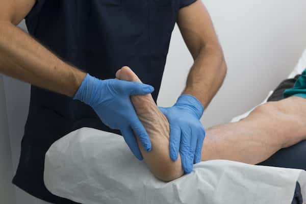 An image of a man getting a foot adjustment from a chiropractor