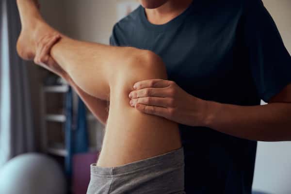 An image of a man getting a knee adjustment from a chiropractor